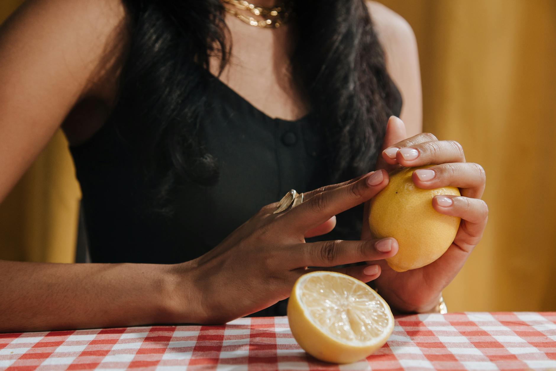 Frau hält frische Zitrone in der Hand, Symbol für Frische und natürliche Vitalität
