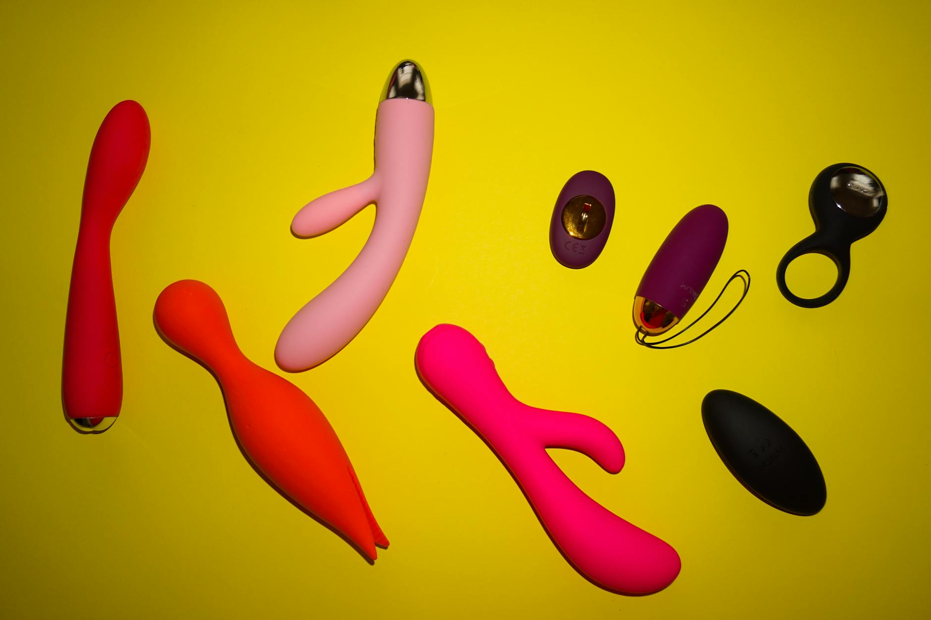 Farbenfrohe Lemon Vibratoren und Sextoys auf gelbem Untergrund, zeigen Vielfalt und Design